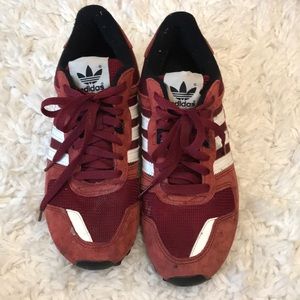 Well-loved maroon and white Adidas sneakers